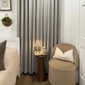 Pinch pleat Natural Beige Orion Linen Look Blackout Curtains styled in a cozy bedroom corner