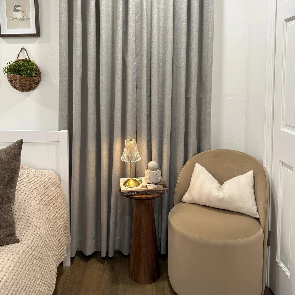 Pinch pleat Natural Beige Orion Linen Look Blackout Curtains styled in a cozy bedroom corner