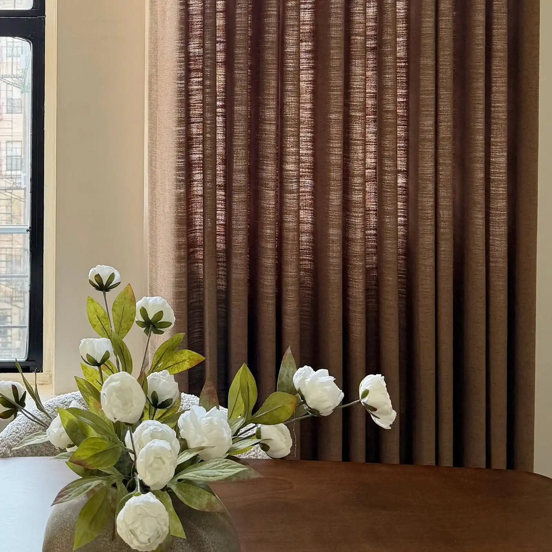 Beautiful drape and folds of Rusty Brown Jasper Dotted Linen Blend Curtains behind a flower vase