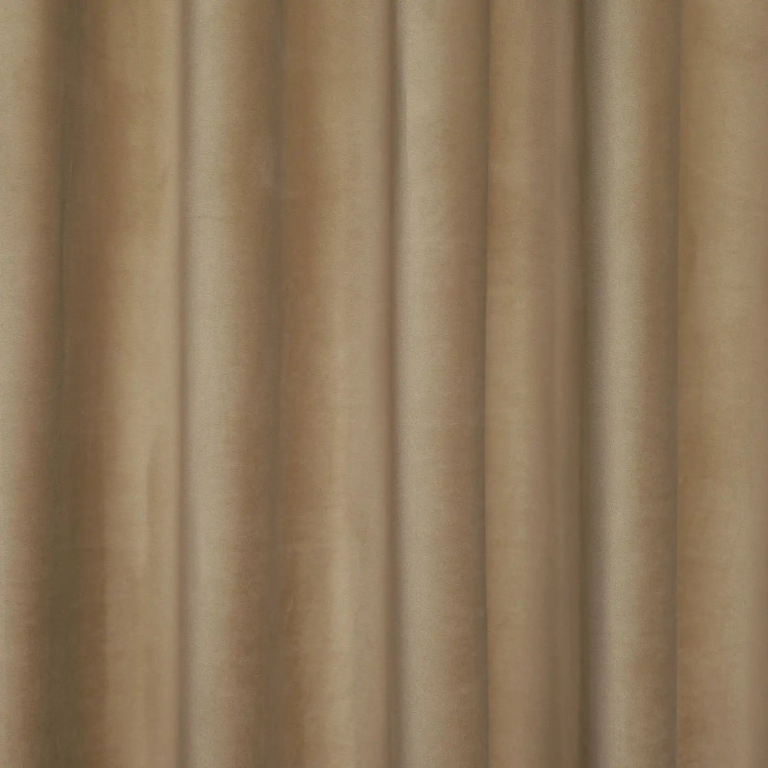 A detail shot showing the tailored heading and top rings of an Adrian Cashmere Blackout Curtain in Camel Yellow as it hangs from a brass rod.