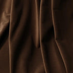 A detailed close-up of the deep brown material folding naturally, highlighting its ultra-soft, velvet-like texture and subtle matte finish.