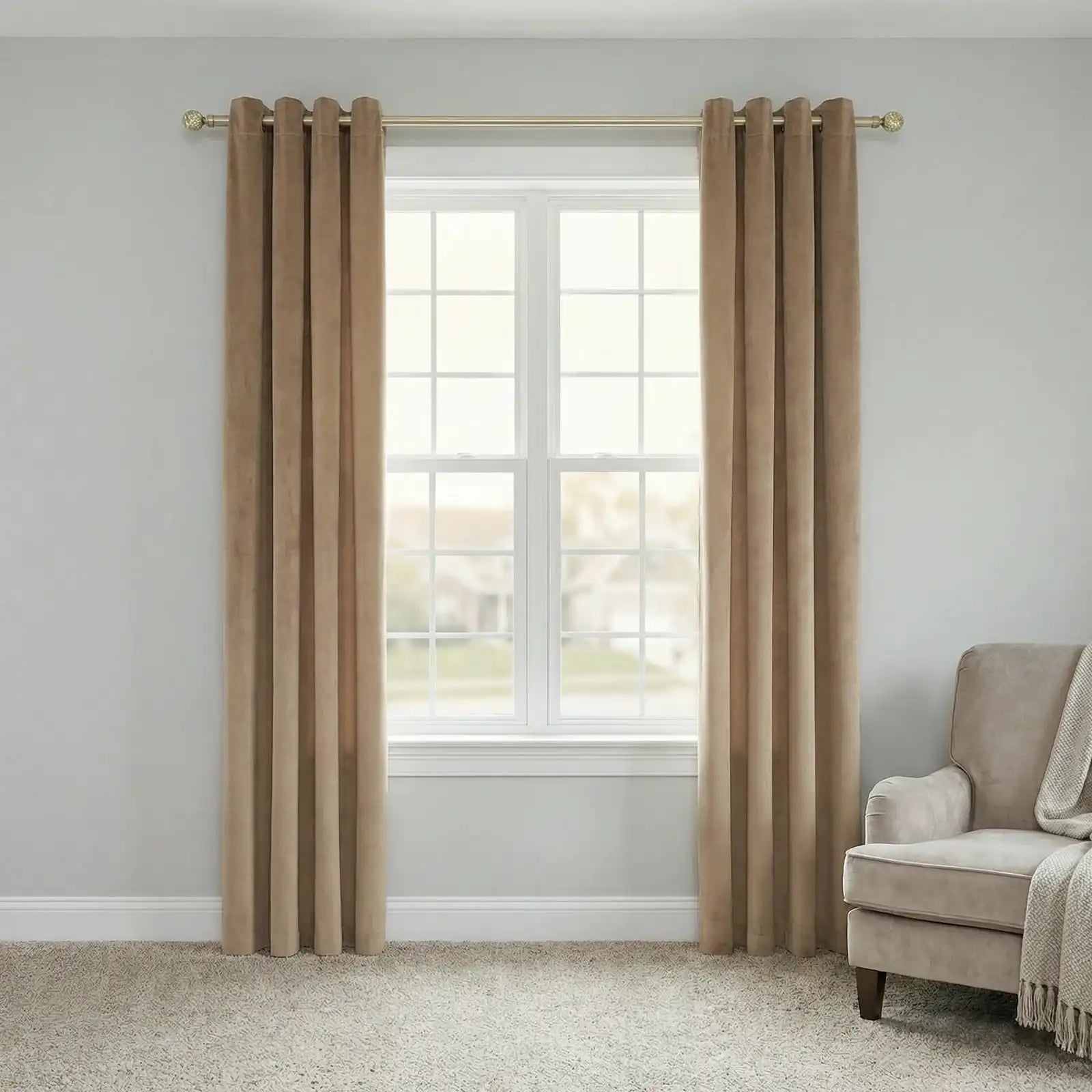 A wide-angle, full-length shot of a white-framed window covered by a pair of fully extended Adrian Cashmere Blackout Curtains in Camel Yellow. The curtains are hung from a simple brass-toned rod.