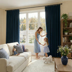 A warm living room scene showing a mother in a light blue dress holding hands with her young daughter on a white rug with a small white dog, while the window is framed symmetrically by two deep sea blue curtain panels.