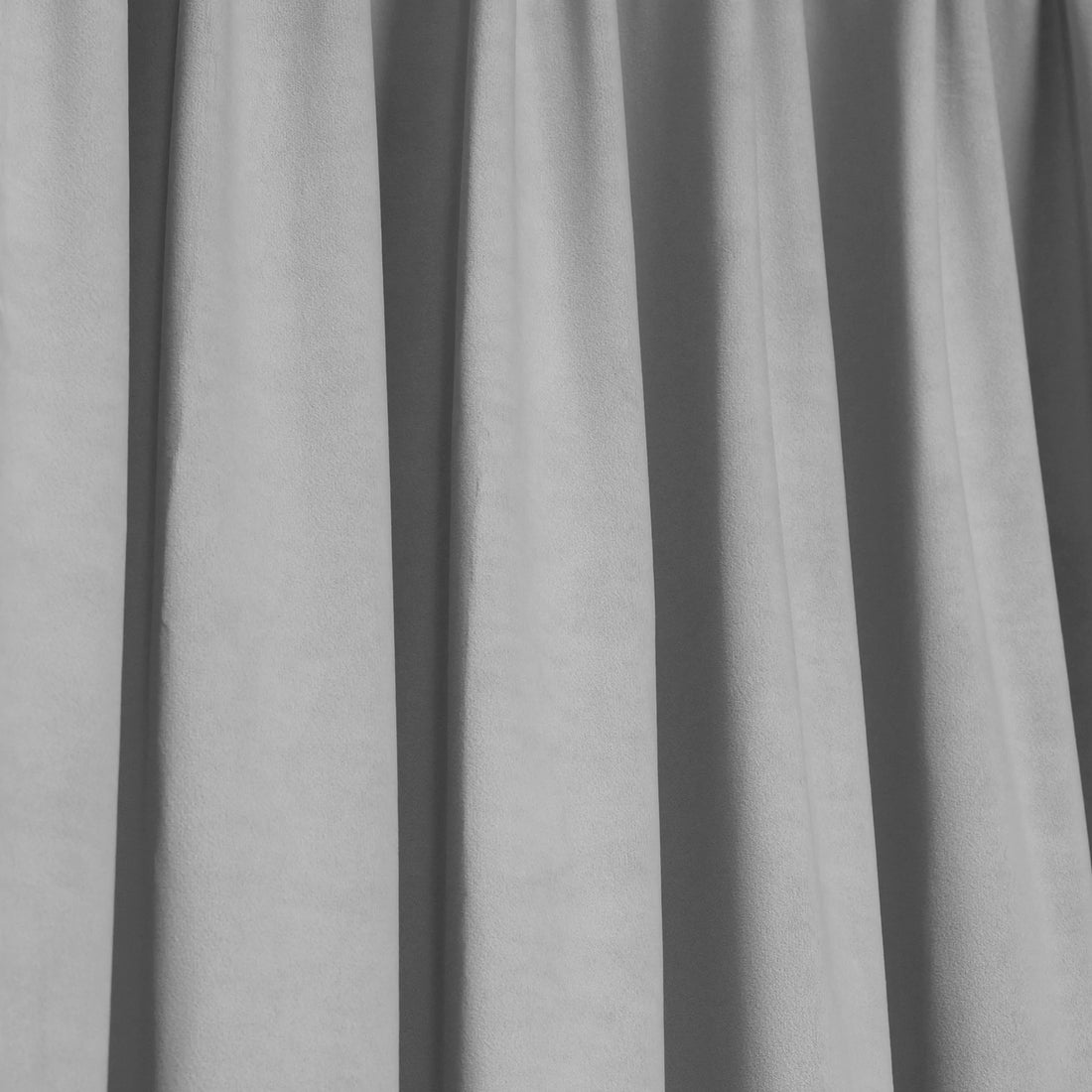 A crisp, full-frame shot showing the uniform, structured pleats and neat vertical folds of the gray curtain fabric.