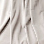 A macro close-up texture shot of the off-white cashmere blackout curtain fabric, showcasing its soft, velvet-like surface and elegant, fluid folds.