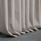 Beige Alex blackout curtain hems pooling neatly on a dark tiled floor