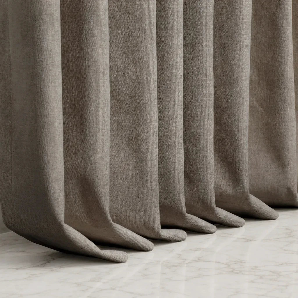 Coffee Alex blackout curtain hems pooling neatly on a light marble floor