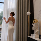 Close view of coffee Alex curtains beside a woman at a sunlit floor-to-ceiling window