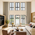 Off-white Alex extra-long blackout curtains framing a bright double-height living room