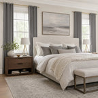 Cool gray Gavin curtains framing a bright neutral bedroom with brass rods