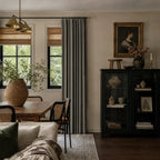 Dark gray Gavin curtains framing a bright neutral bedroom with brass rods