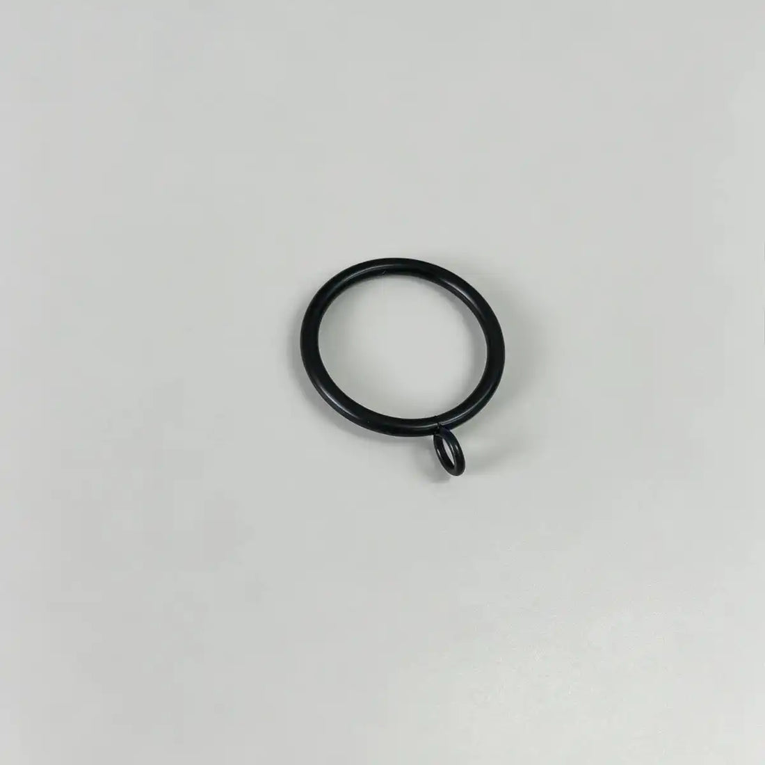 Close-up of black steel curtain rings with attached loops, used for hanging curtains, shown on plain white background