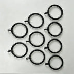 Close-up of black steel curtain rings with attached loops, showing size and design for hanging curtains, SKU: AGPC70-1