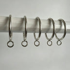 Stainless steel curtain rings with hooks arranged on a white surface, shiny and durable, ideal for window treatments, SKU: AGPC70-1