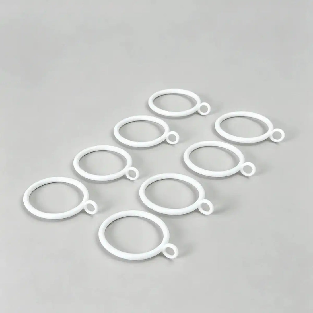 Multiple white steel curtain rings with loops hanging on a curtain rod, for home decor and window treatment accessories, SKU: AGPC70-1