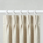 White fabric curtain with white metal rings for easy hanging, mounted on a white curtain rod for home window decor