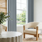 Cream boucle chair paired with Blue Gray John Linen Texture Cotton Curtains hanging neatly near a garden view window