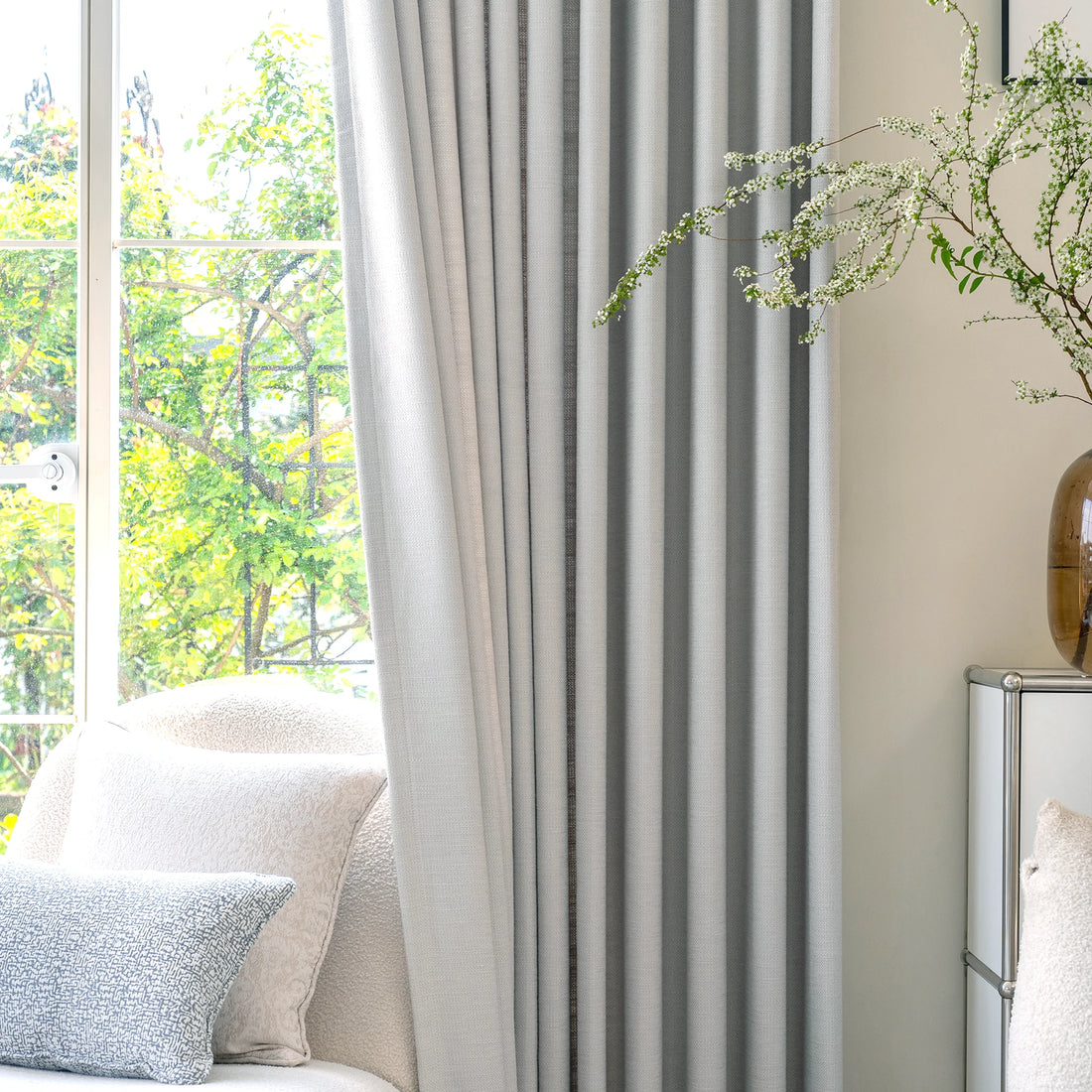 Tailored pinch pleat drape of Light Gray John Linen Texture Cotton Curtains hanging near a cozy lounge setup
