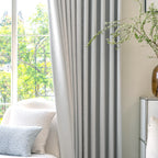 Tailored pinch pleat drape of Light Gray John Linen Texture Cotton Curtains hanging near a cozy lounge setup