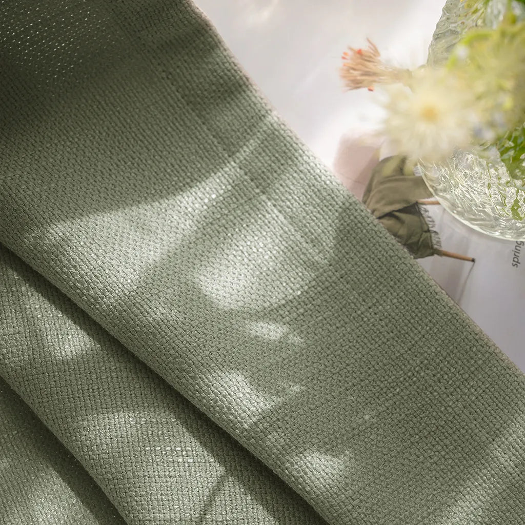Close up organic slub weave detail of Grass Green John Linen Texture Cotton Curtains in natural sunlight