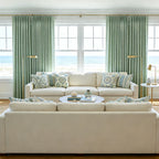 Ocean view lounge room featuring symmetric layouts of Grass Green John Linen Texture Cotton Curtains behind neutral couches