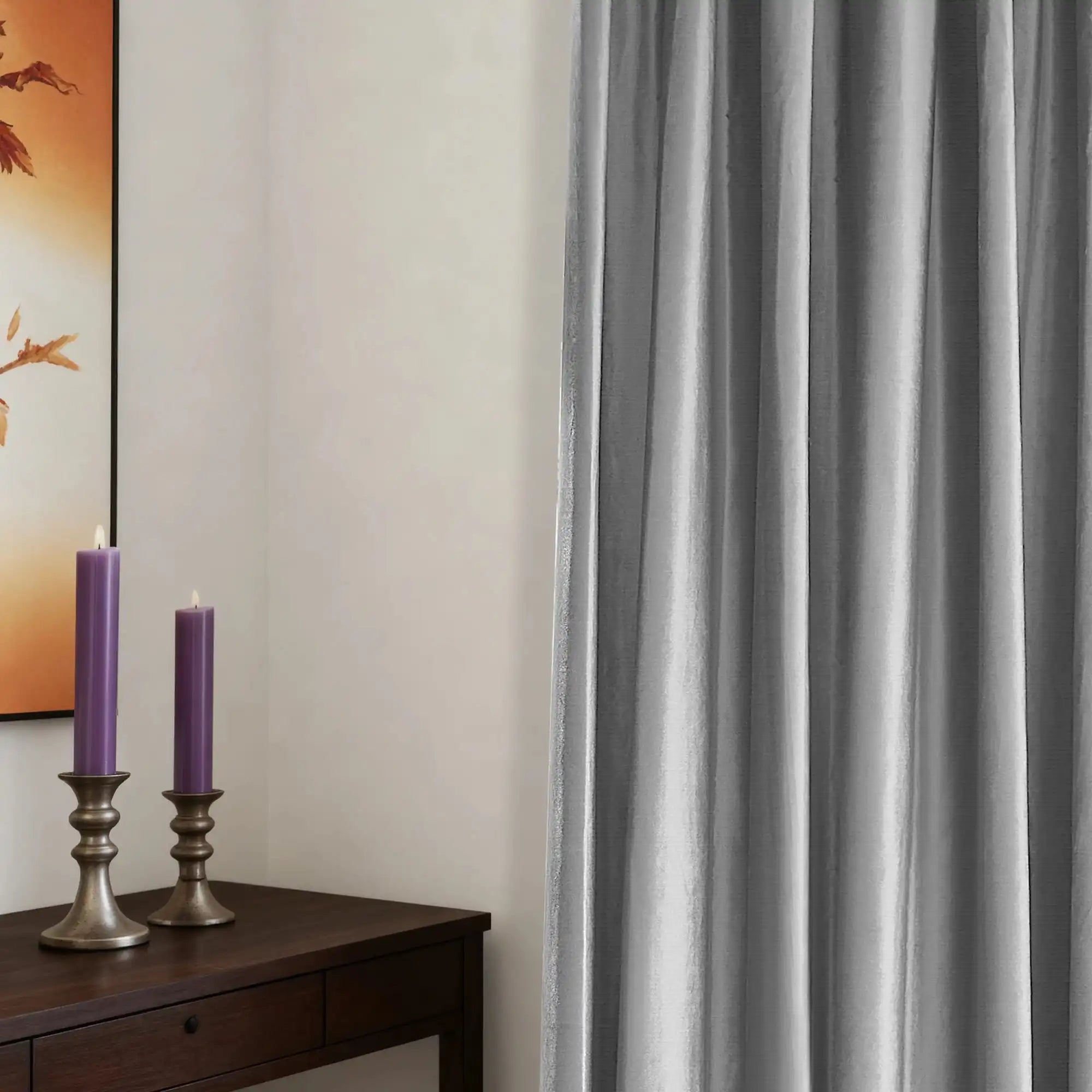 Gray velvet curtains with textured fabric hanging on a wooden rod, in a minimalist room with white walls and a large window.