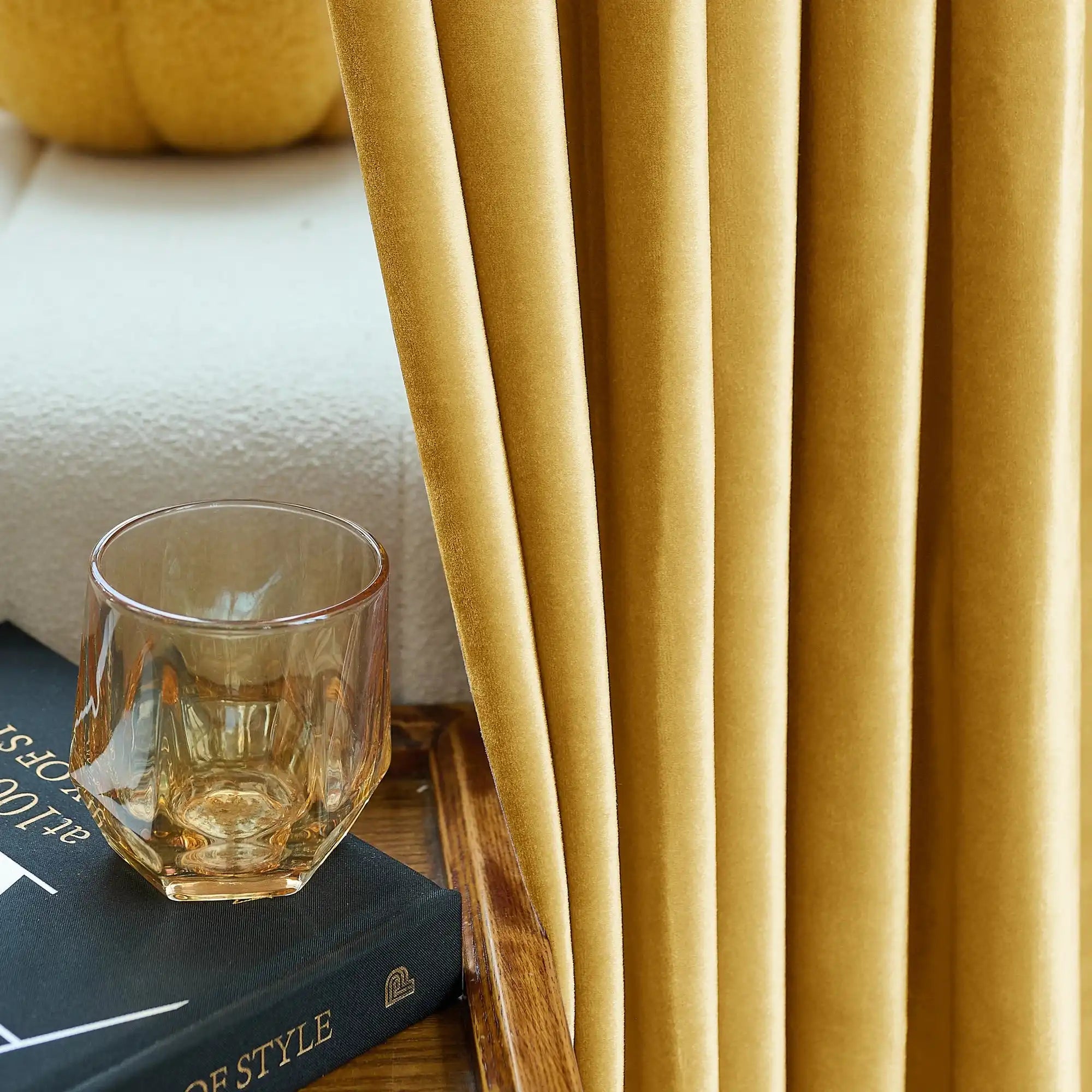 Yellow velvet drapes with a soft, plush texture, draped in a cozy living room setting, complemented by a string of white pearls for a luxurious look