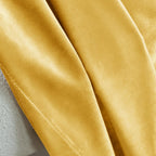 Detailed view of yellow velvet fabric with a smooth, velvety surface, showcasing the rich texture and luxurious quality of the curtains