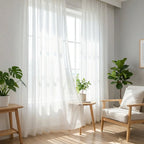 Sun drenched reading corner featuring fluid White Lisa Semi Sheer Curtains and lush green houseplants
