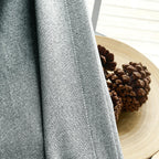 Fabric texture close up of White Gray Orion Linen Look 100 percent Blackout Curtains next to pinecones