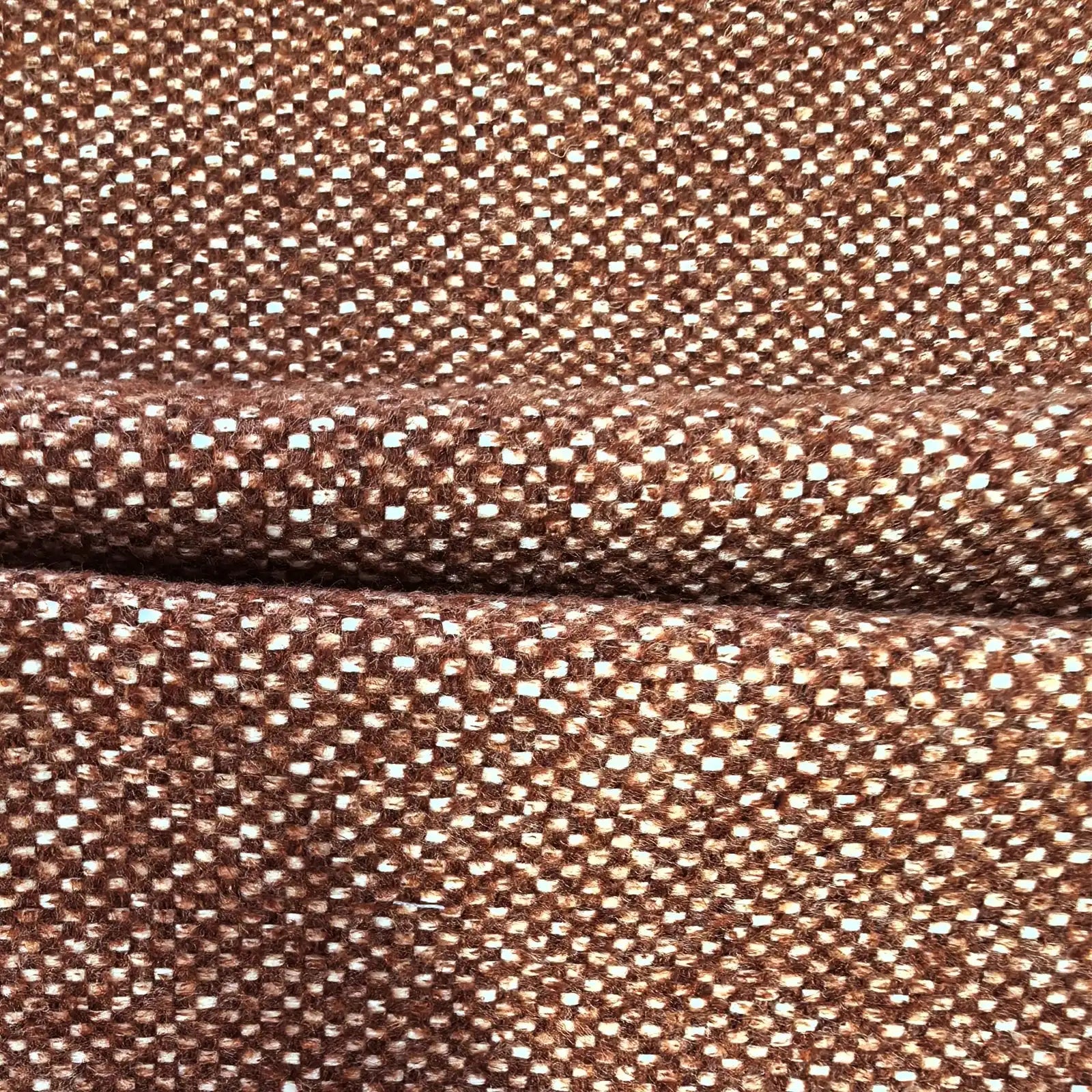 A close-up view of the multi-tonal caramel and white curtain fabric, neatly pressed into a horizontal fold across the middle to showcase its clean drape and uniform texture.