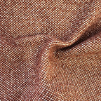 A close-up texture shot of the rich caramel-brown fabric with an organic, wavy rumple near the center. The detailed basketweave pattern shows a tight grid of warm coppery-brown and contrasting white threads.