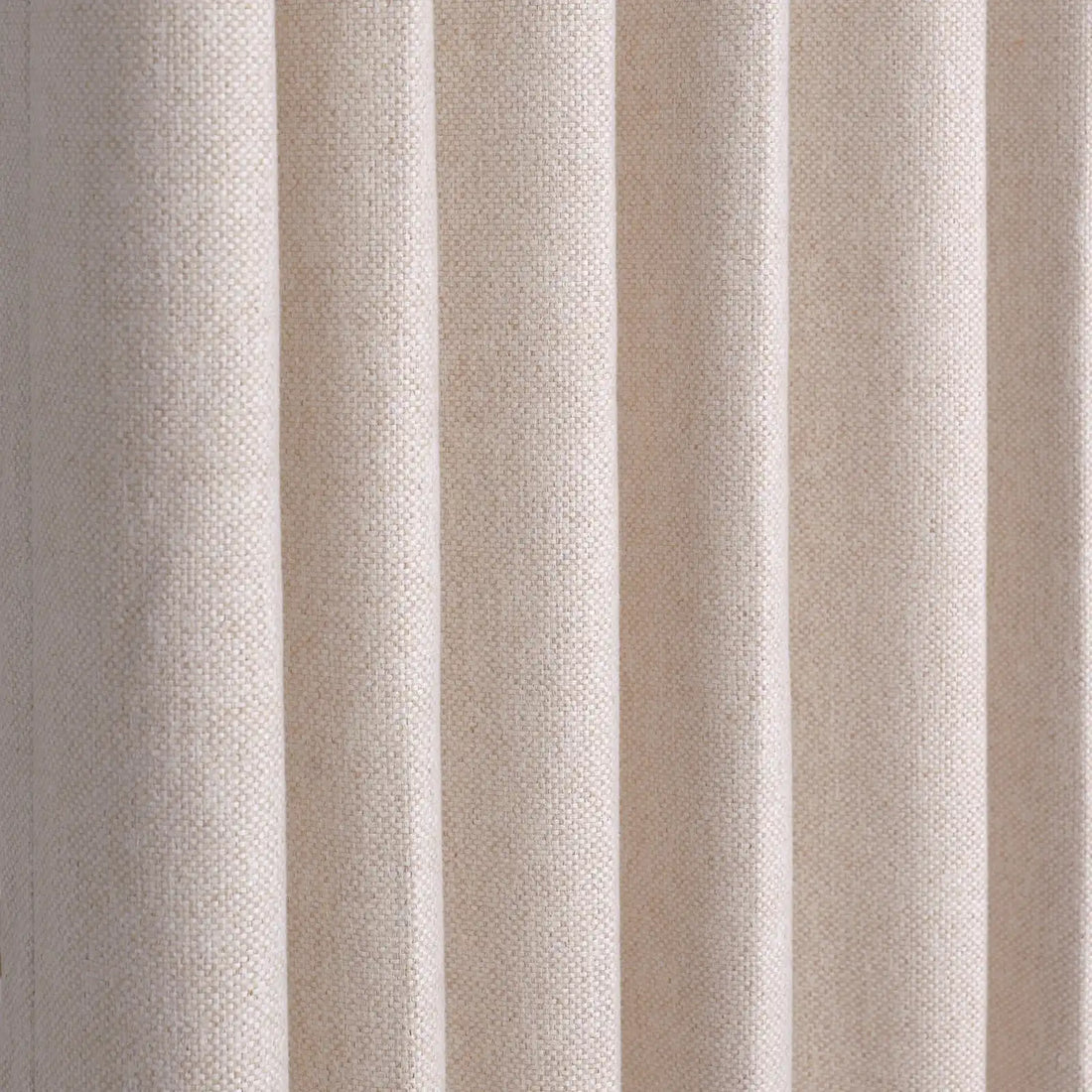 A full-frame close-up showing the precise, structured vertical pleats of the hanging light yellow curtain, highlighting its uniform drape and woven linen-style texture.