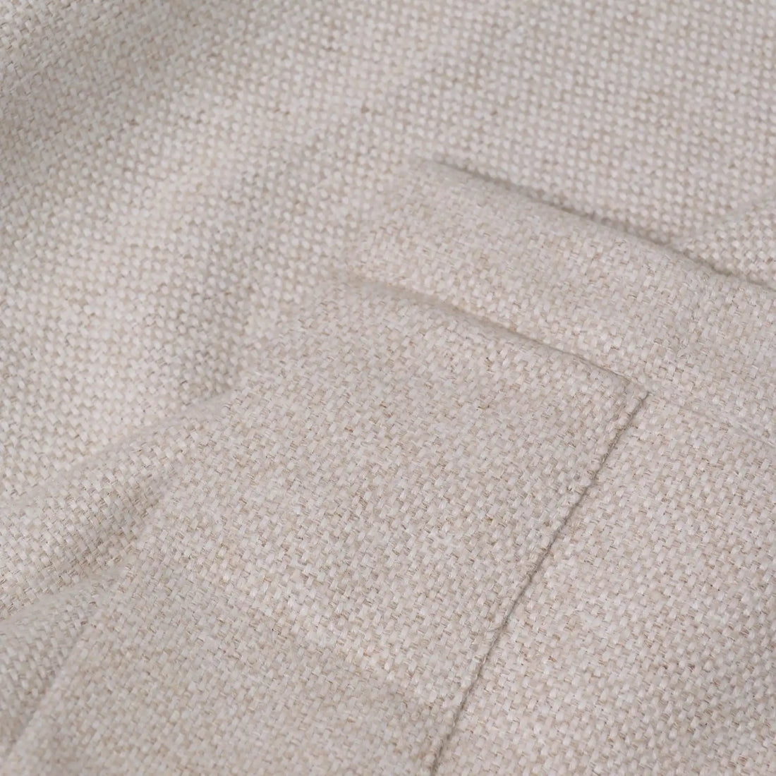 A close-up view of the light yellow, oatmeal-textured fabric showing a neatly stitched hemmed edge, highlighting the high-quality, dense weave of the material.