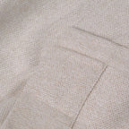 A close-up view of the light yellow, oatmeal-textured fabric showing a neatly stitched hemmed edge, highlighting the high-quality, dense weave of the material.