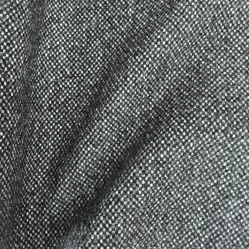 A detailed close-up shot of the dark gray curtain fabric cascading in soft, undulating diagonal folds, emphasizing its premium weight, depth, and multi-tonal charcoal-and-white woven texture.