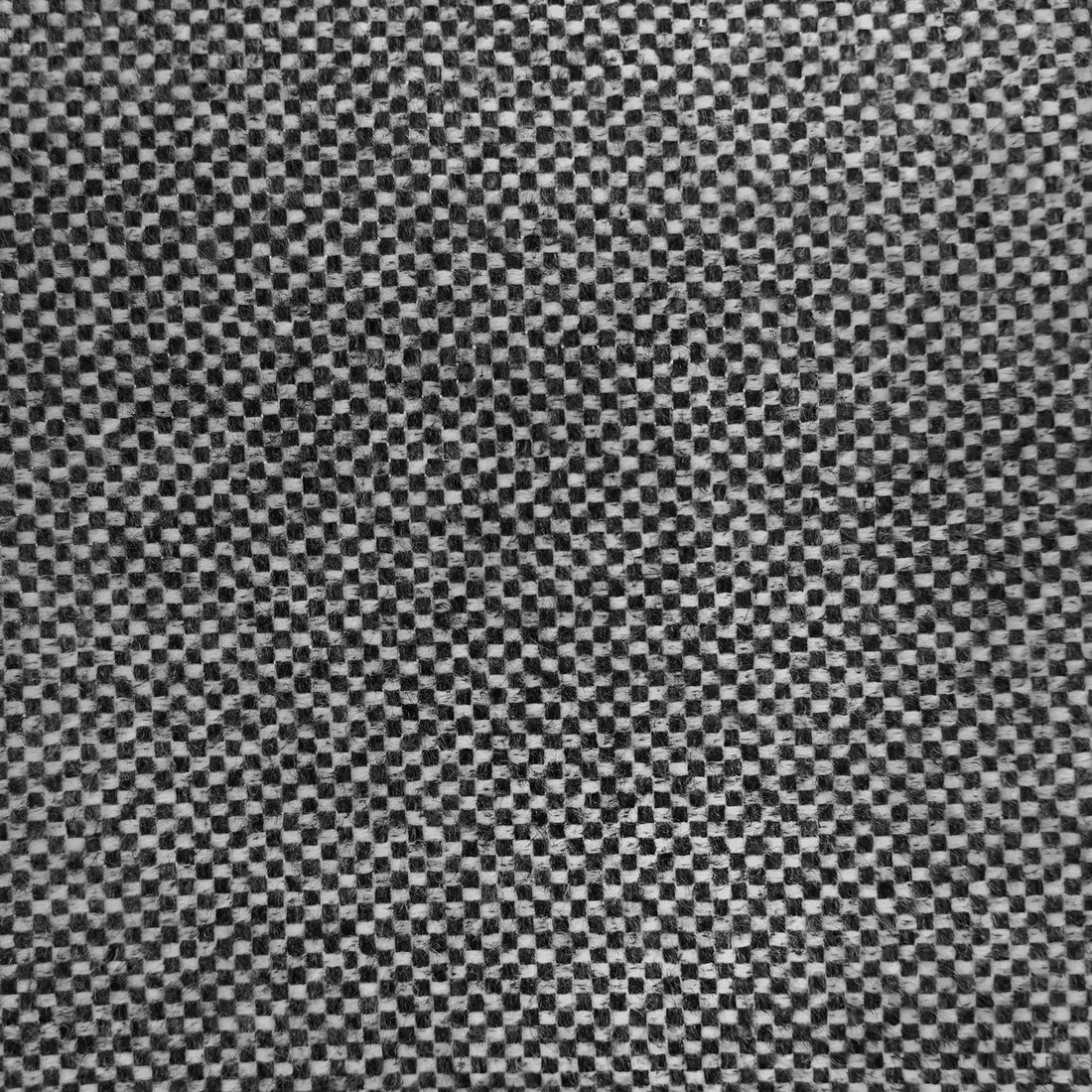 A close-up texture shot of the dark gray fabric, featuring a soft, organic rumple in the center that highlights the rich basketweave pattern of interwoven dark charcoal and contrasting off-white threads.