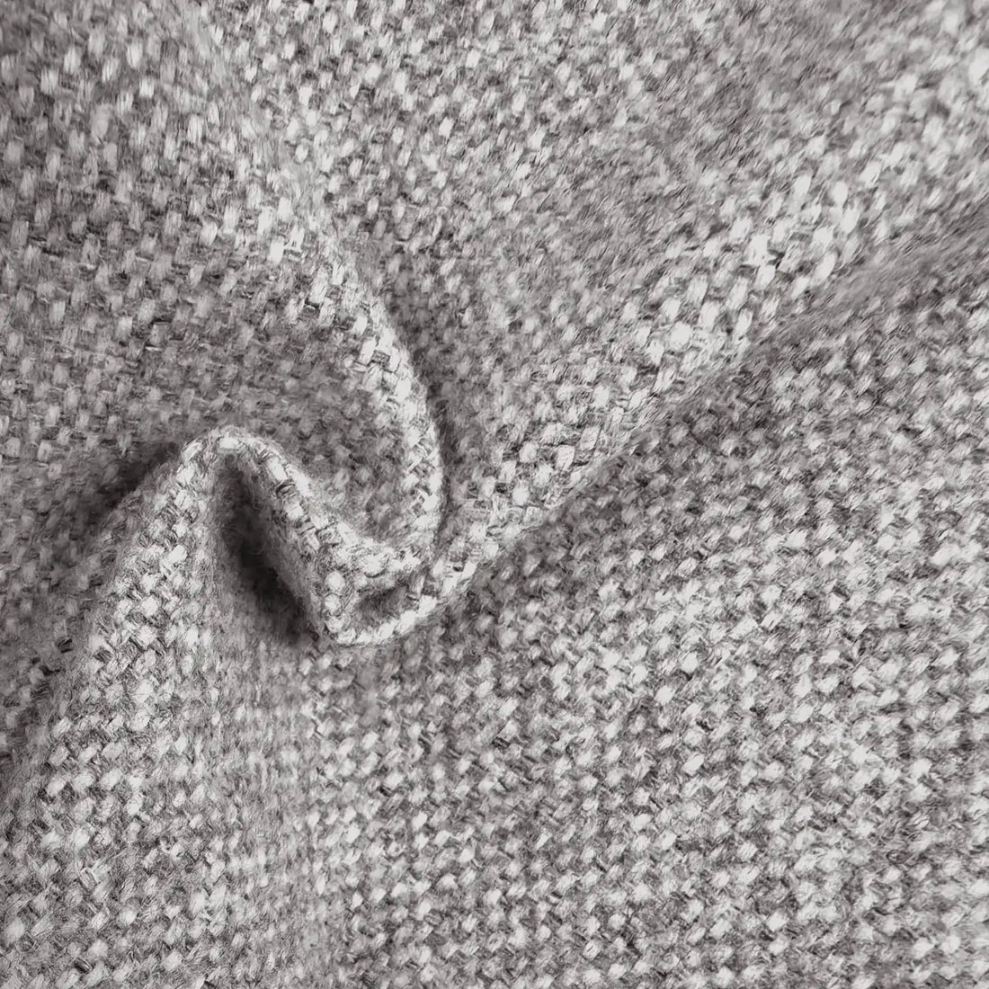 A close-up view of the gray textured fabric gathered into a soft, wavy ripple, showcasing the interlaced gray and white threads and the heavy, natural drape of the material.