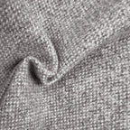 A close-up view of the gray textured fabric gathered into a soft, wavy ripple, showcasing the interlaced gray and white threads and the heavy, natural drape of the material.