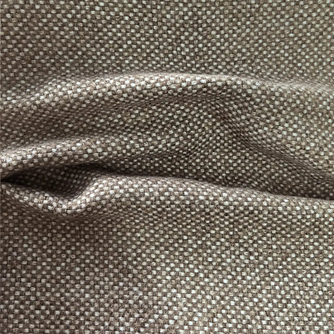 A close-up shot of the grayish-brown curtain material creating deep, horizontal folds and shadows, emphasizing its thickness, structure, and premium weight.