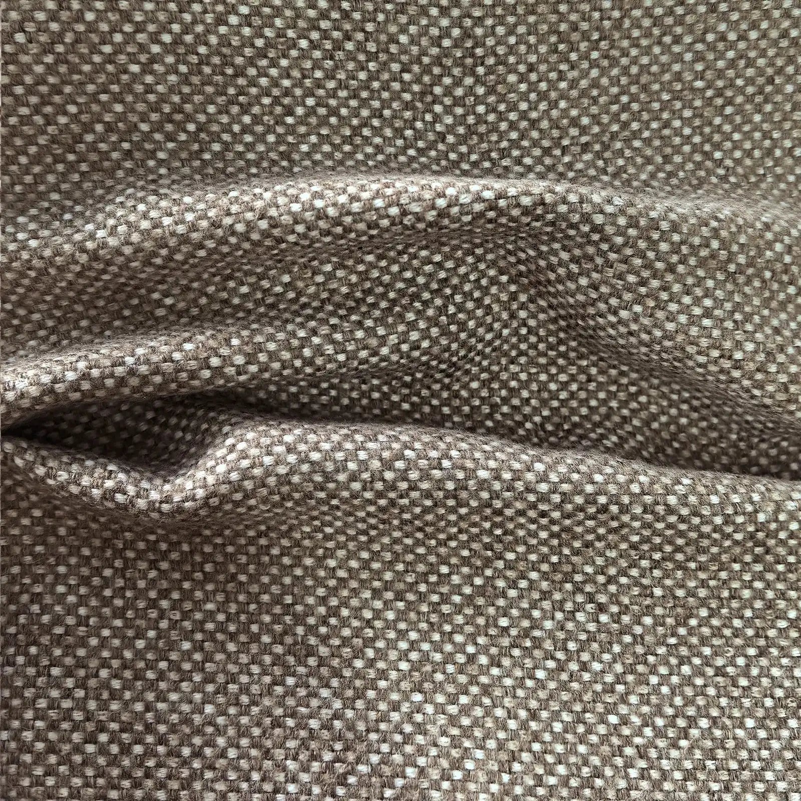 A close-up shot of the grayish-brown curtain material creating deep, horizontal folds and shadows, emphasizing its thickness, structure, and premium weight.