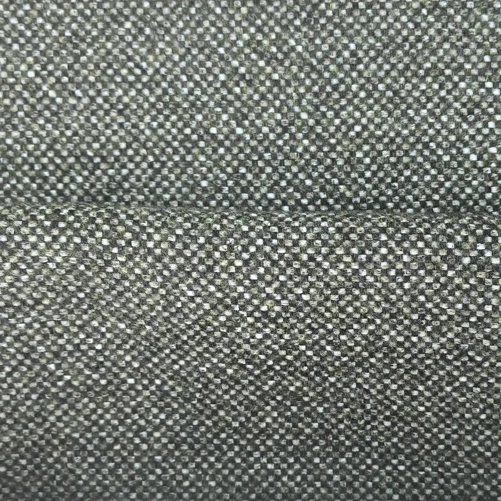 A close-up, full-frame shot of the forest green fabric showing a soft horizontal ridge or fold across the center. The detailed basketweave pattern reveals a tight, intricate mix of dark green, sage, and off-white threads.