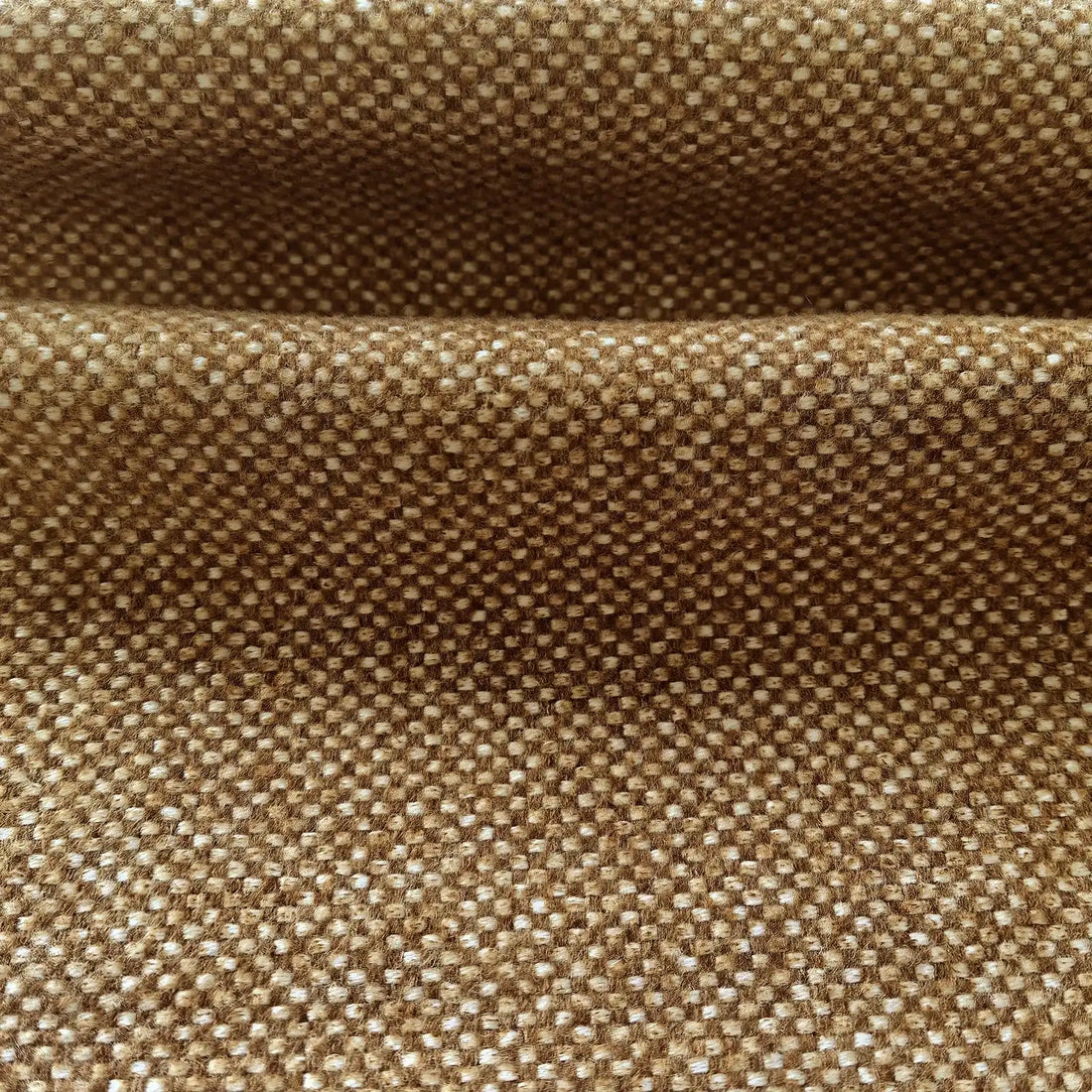 A detailed close-up shot of the light brown woven fabric folded horizontally, showcasing its thick, tactile texture and clean, well-defined weave.