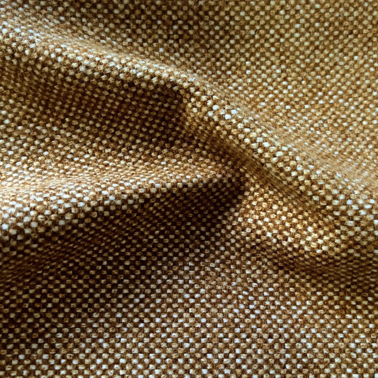A close-up texture shot of the light brown fabric, featuring a soft, organic rumple in the center that highlights the rich basketweave pattern of interwoven golden-brown and off-white threads.