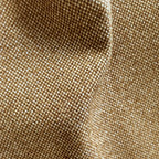 A close-up texture shot of the light brown fabric, featuring a soft, organic rumple in the center that highlights the rich basketweave pattern of interwoven golden-brown and off-white threads.