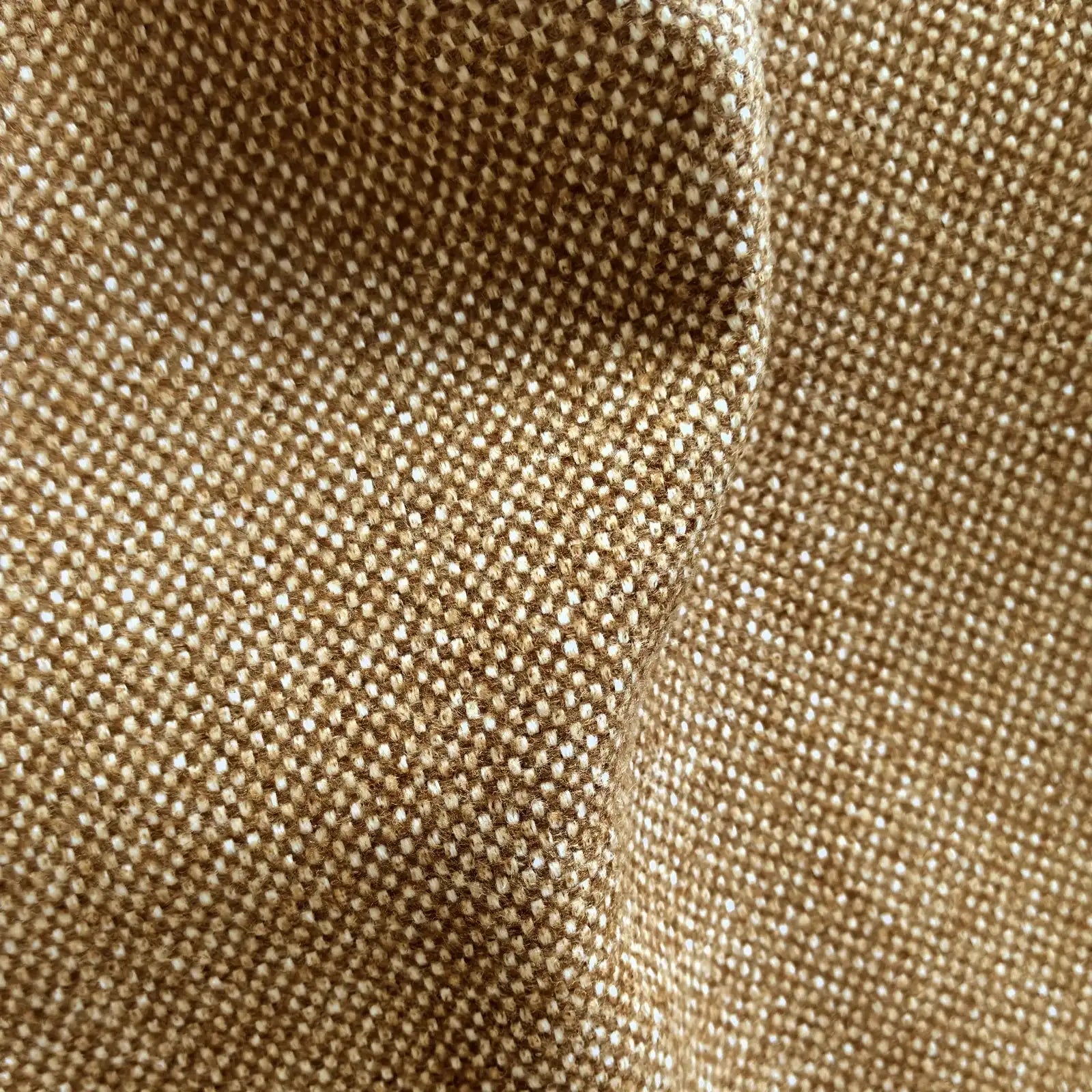 A close-up texture shot of the light brown fabric, featuring a soft, organic rumple in the center that highlights the rich basketweave pattern of interwoven golden-brown and off-white threads.
