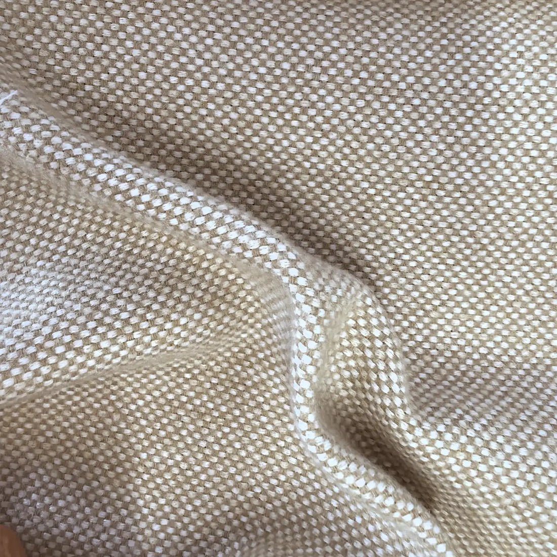 A close-up macro shot of the light oatmeal-yellow fabric, showing a soft, organic rumple in the center. The intricate basketweave texture clearly reveals alternating off-white and soft tan-yellow threads.