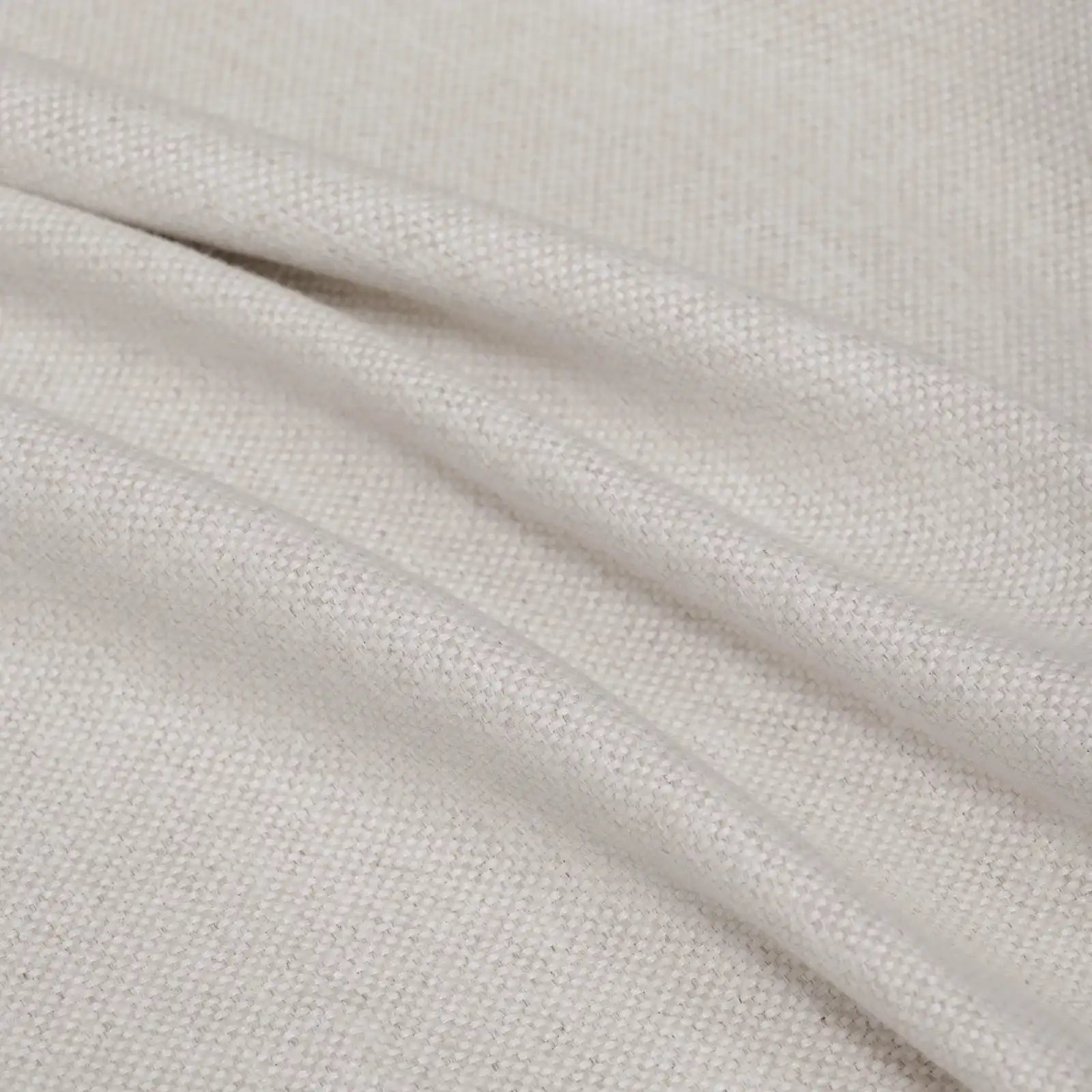 A soft, full-frame shot of the light yellow curtain material arranged in fluid diagonal folds, showcasing its rich tactile quality and light-catching weave.
