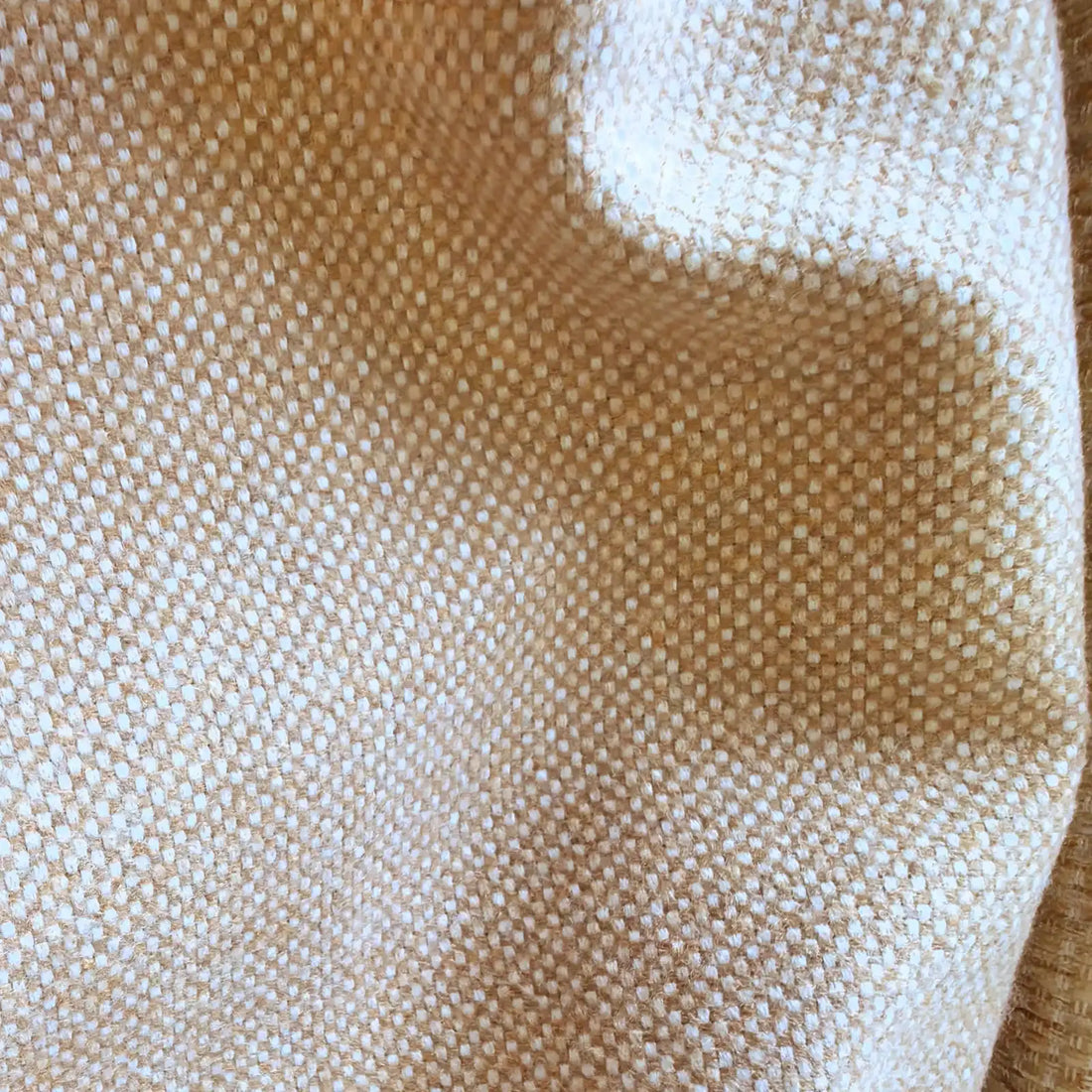 A close-up texture shot of the mustard-yellow heathered fabric cascading in soft, undulating curves, emphasizing its premium weight and multi-tonal woven quality.