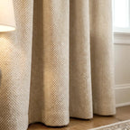 A close-up view focusing on the lower section of the mustard-yellow curtain panel, highlighting its clean, uniform vertical pleats as they hang neatly near a window frame.